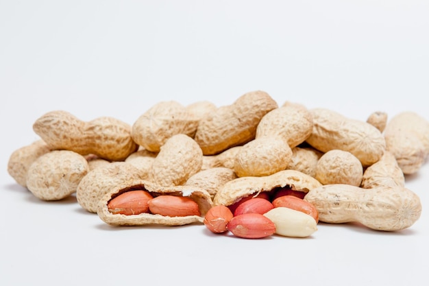 Large peeled peanuts closeup of beans in the shell Unpeeled peanuts in the shell Peanuts for background or texture Growing organic protein