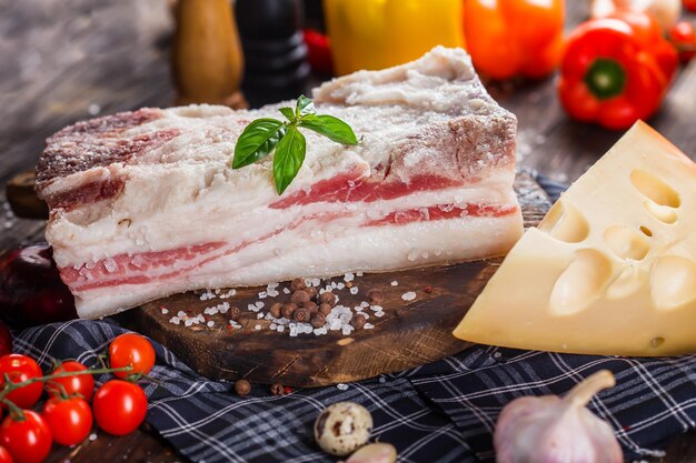 large piece, fresh lard pork lard with salt, on a kitchen cutting board, hard cheese dark and moody,