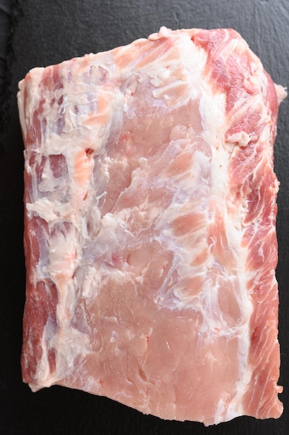 A large piece of pork loin on a rustic dark background