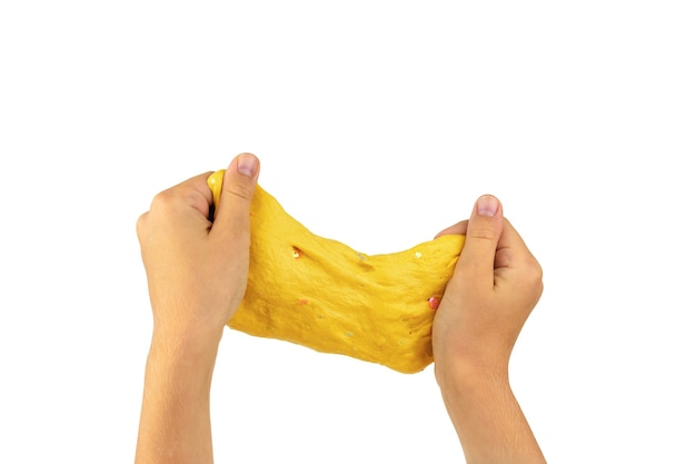 A large piece of yellow slime in the hands of a child isolated on a white background.