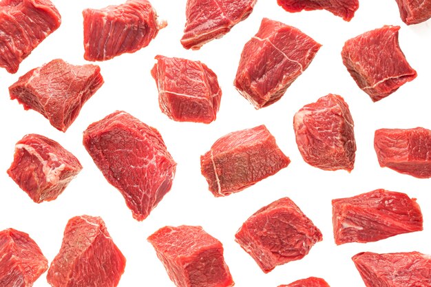 Grandi pezzi di carne di manzo su uno sfondo bianco di isolare. cubetti di carne rossa affettata, sfondo per cucinare, ristorante, macelleria.