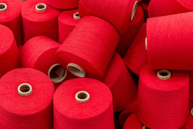 Photo a large pile of spools of red thread. close up