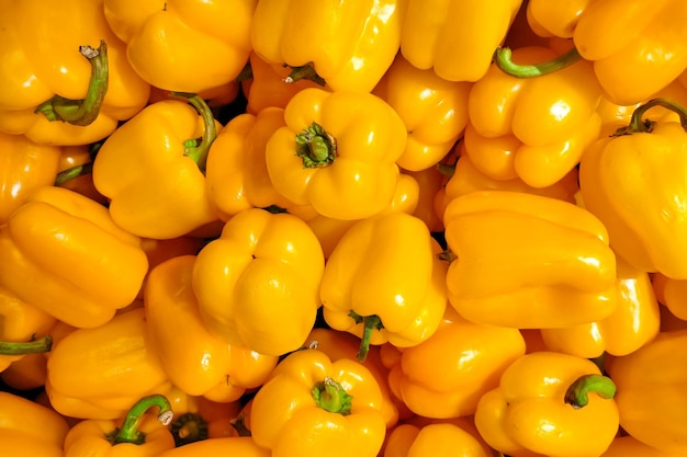 Photo large pile of yellow sweet peppers on market counter food background