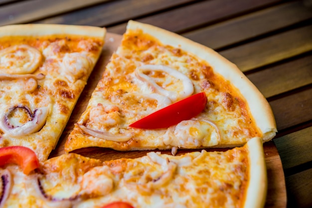 Large pizza on a wooden table.