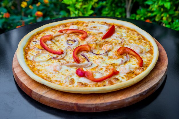 Large pizza on a wooden table.