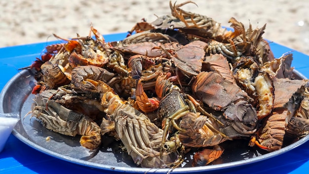 Large plate with a grilled seafood lobsters. BBQ exotic food on the beach. Selective focus.