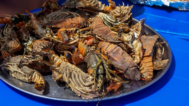 구운 해산물 랍스터가 담긴 큰 접시. 해변에서 이국적인 음식을 바베큐하십시오. 선택적 초점입니다.