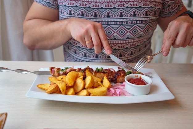 Large plate with shish kebabs and fried potatoes