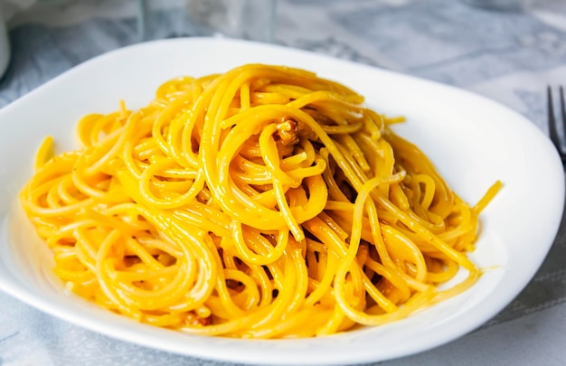 Large portion of spaghetti carbonara in a white dish italian food typical roman cuisine