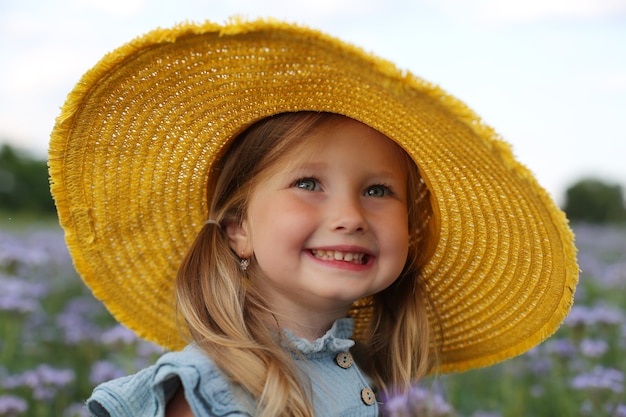 Grande ritratto di una bella ragazza bionda con un cappello giallo