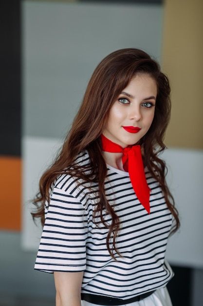 A large portrait of a beautiful girl in a striped blouse and a red scarf aroun