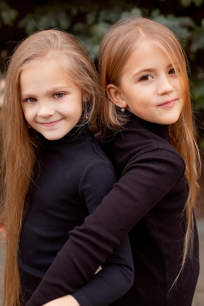 a large portrait of two blonde girls girlfriends with long hair in black sweatshirts