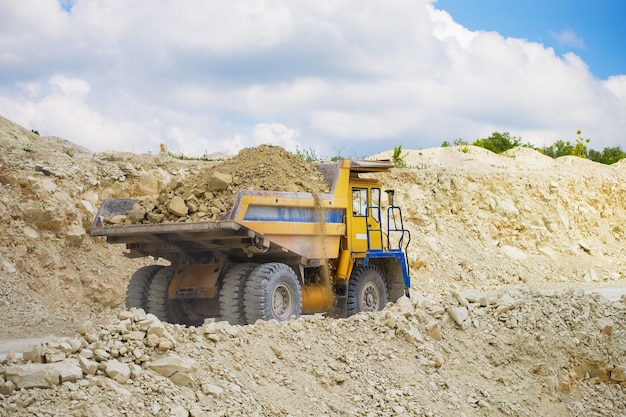 Grande autocarro con cassone ribaltabile della cava caricato con roccia