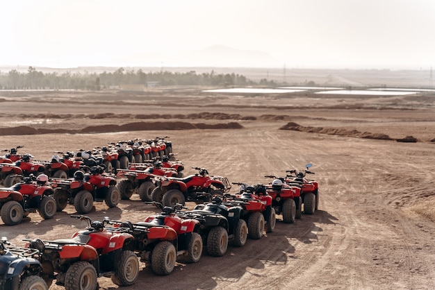 Large queue of ATVs and buggies stand in the middle of a sandy desert