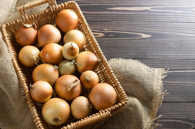 Large raw organic onions on wooden background Selective focus