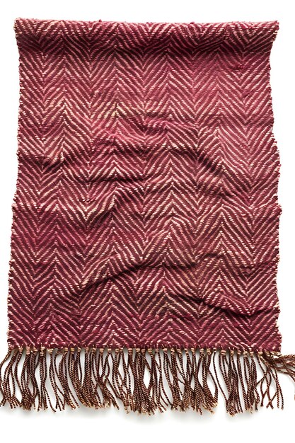 a large red and brown rug with a fringed design