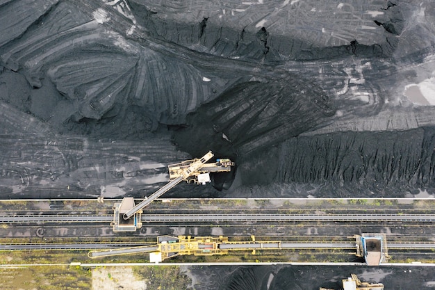 Large reserves of coal at a power plant, many cranes unloading
coal, a lot of coal, top view