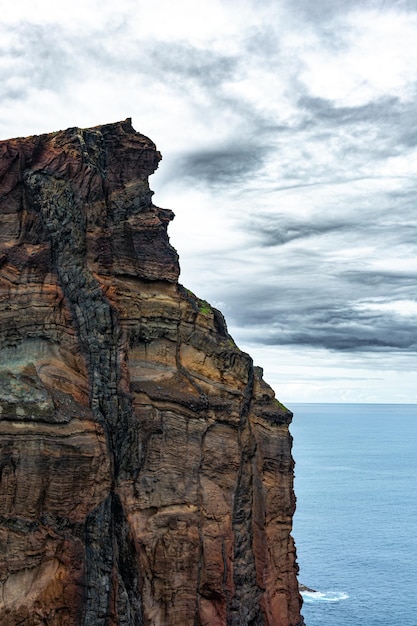 Foto una grande parete rocciosa con un cielo blu sullo sfondo