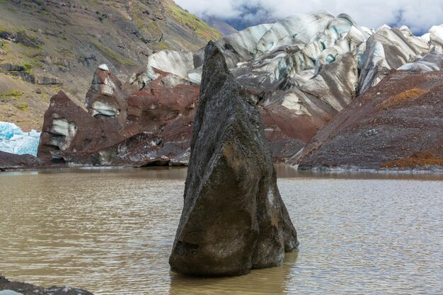 Foto una grande roccia in mezzo a un lago