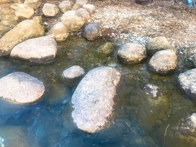 Большие круглые красивые натуральные камни булыжники в воде море озеро река Фоновая текстура