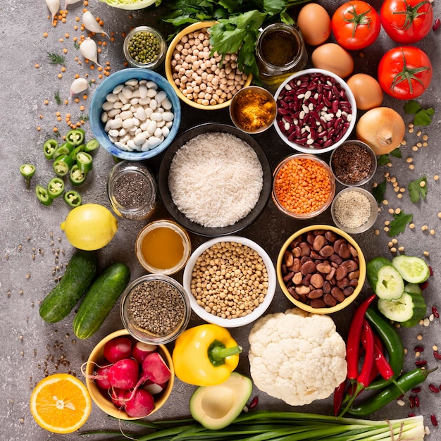 Большой набор сбалансированных продуктов питания на сером бетонном фоне верхний вид Овощи фрукты орехи зерна оливковое масло зеленые травы
