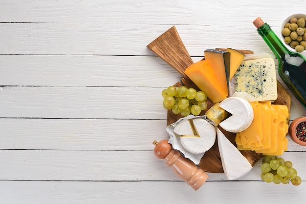 A large set of cheeses Mozzarella blue cheese brie cheese maasdam Top view On a white wooden background Free space for your text