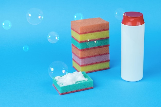 A large set of foam sponges and cleaning agent on a blue background