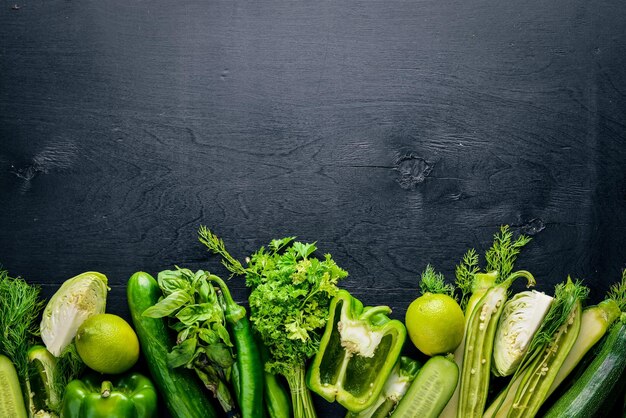 A large set of green vegetables on a wooden background Top view Free space