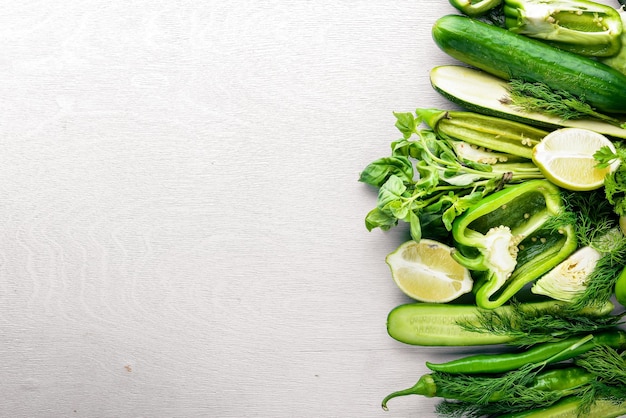 A large set of green vegetables on a wooden background Top view Free space