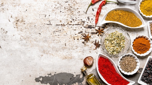 Large set of spices and herbs in the cups.