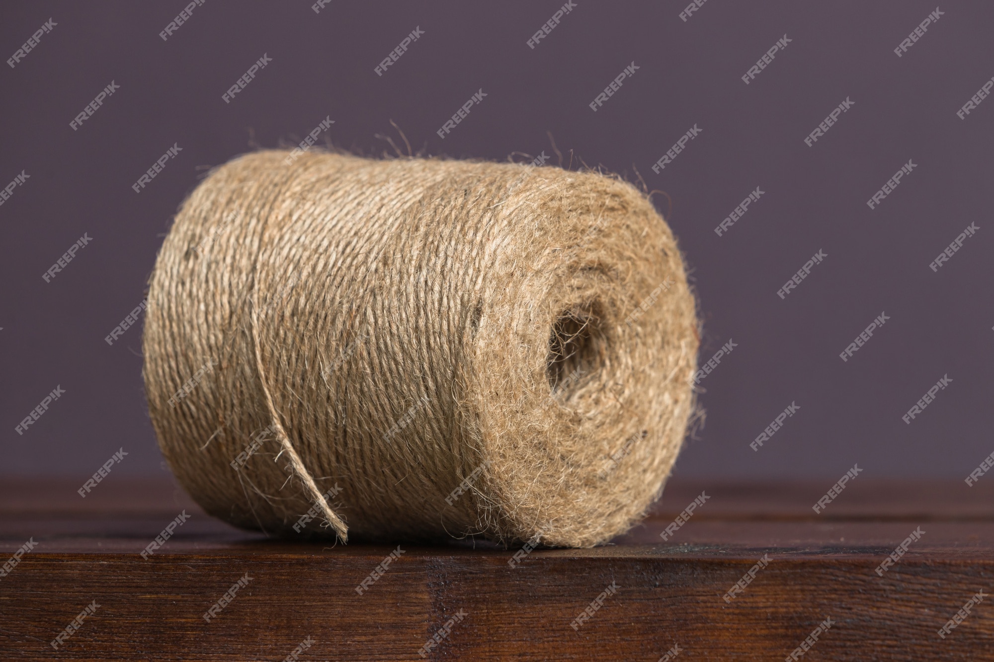 Premium Photo  A large skein of brown twine lies on a wooden shelf on a  plain background