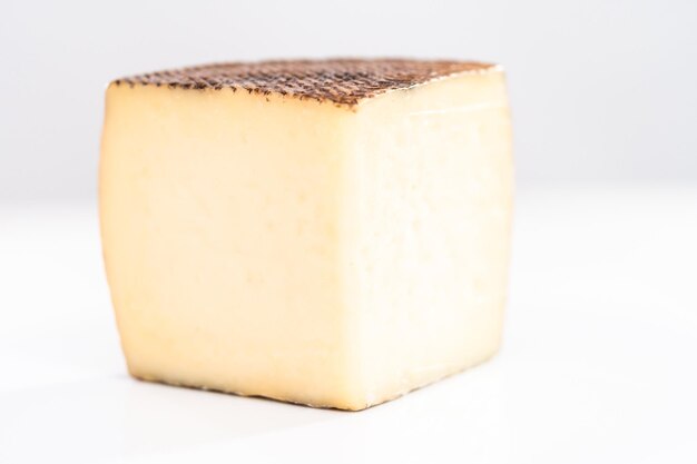 Large slice of aged Manchego cheese on a white background.