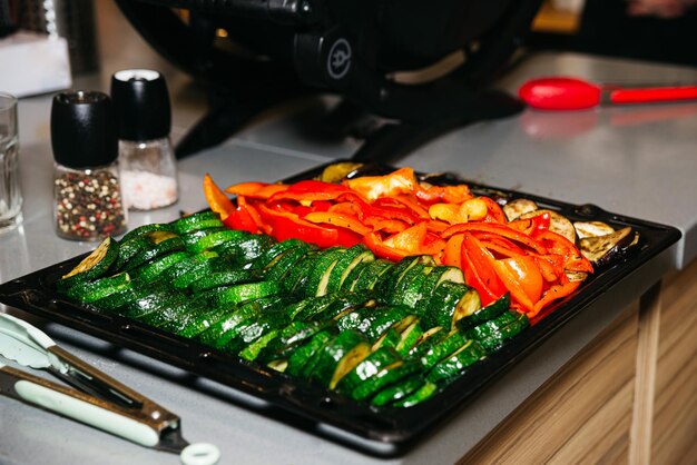 Foto grandi fette e pezzi di zucchine e paprika coperti di olio con spezie