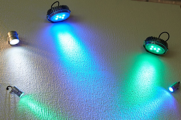 Большой и маленький цветные светодиодные прожекторы на стене.