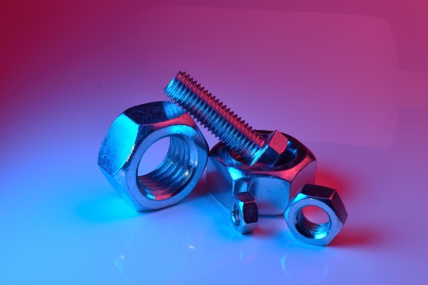 Large and small nuts and bolts highlighted in different colors on a light background