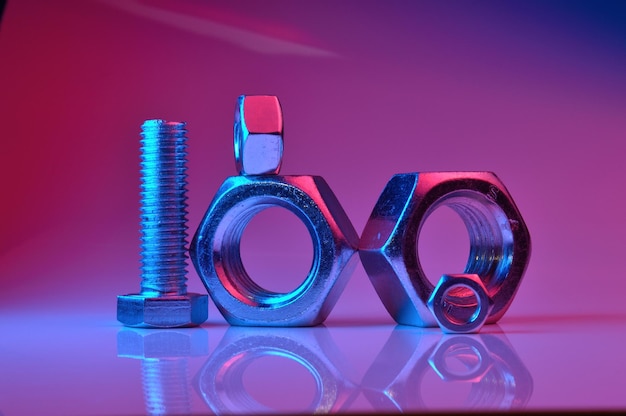 Large and small nuts and bolts highlighted in different colors on a light background