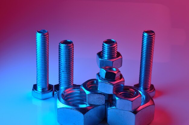 Large and small nuts and bolts highlighted in different colors on a light background