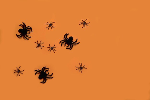 Large and small plastic tarantula spiders on an orange background halloween concept background for a halloween project