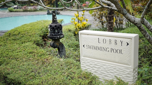 Large square stone information sign with black letters to show directions to swimming pool area