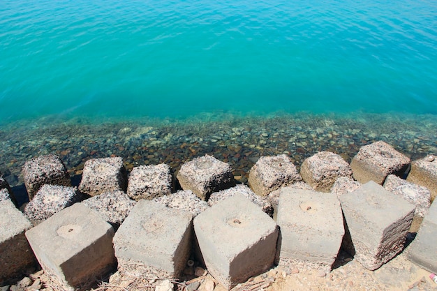 Large square stones breakwaters on seashore of Red Sea Seaside is made of stones and concrete slabs