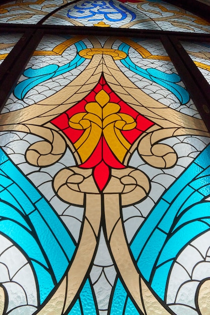 色付きの模様入りガラスの大きなステンドグラスの窓。大聖堂