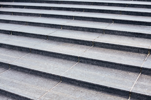 Large staircase with stone-like grey texture, wide granite ladder, front view. Wide stone stairs, abstract stairs, stairs in city, granite stairs, stone stairway often seen on landmarks and monuments