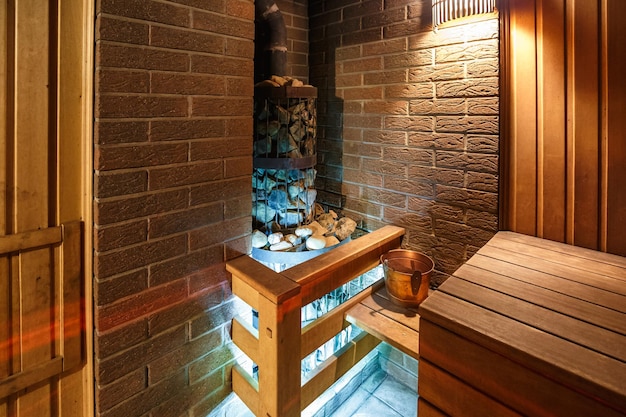 Large standard design classic wooden russian bath sauna interior with hot stones