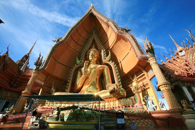 A large statue of author sits in front of a large building.