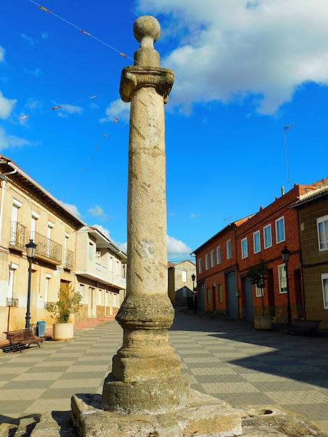 Photo a large stone pillar in a plaza with a sign that says 