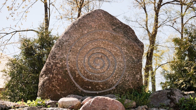 Foto grande pietra con una runa. spirale celtica su pietra.