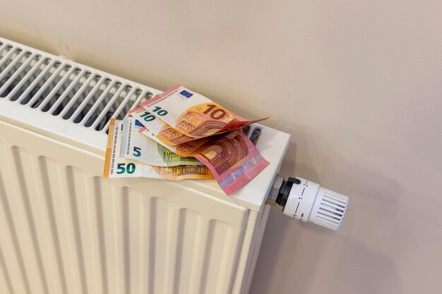 Photo large sum of money in euros on a heating radiator