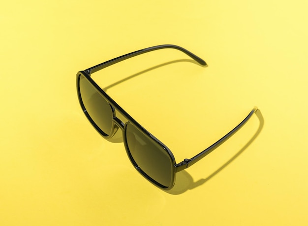 Large sunglasses on a bright yellow background