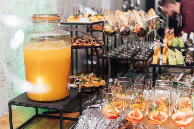 Large table with snacks of different types at a party with creative disco lighting