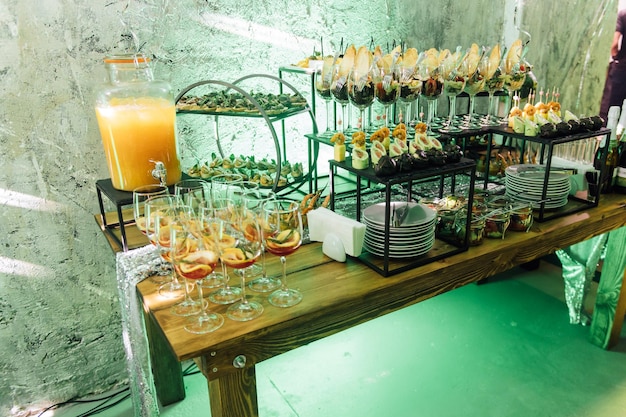 Large table with snacks of different types at a party with creative disco lighting